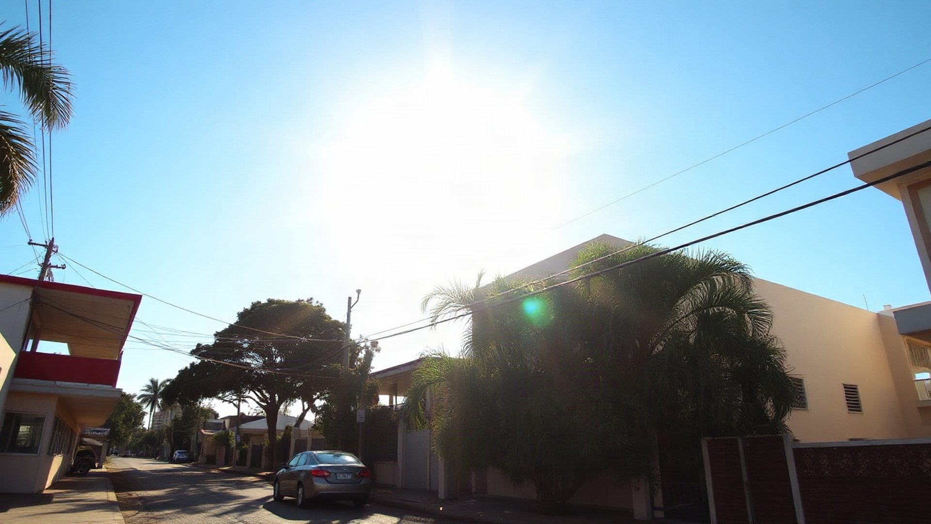 Rua ensolarada de um bairro em Fortaleza sob o céu azul equatorial